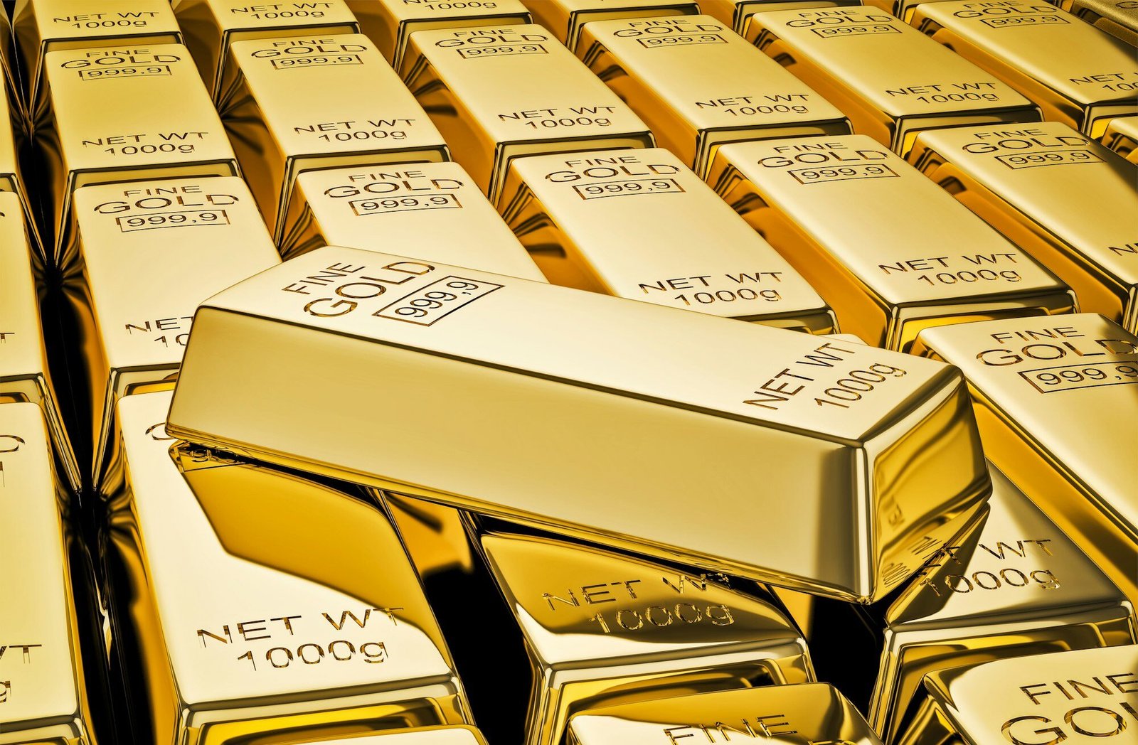 Gold bar on stacks of gold bullions close up